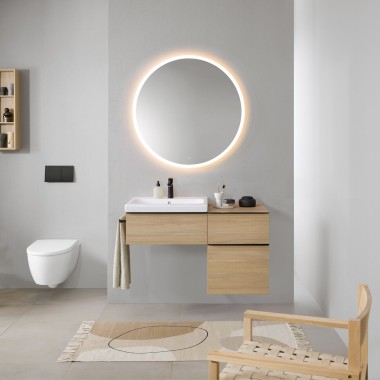 Kupatilo sa sivim zidovima, Geberit kupatilski nameštaj od drveta i okruglo Geberit Option ogledalo sa osvjetljenjem