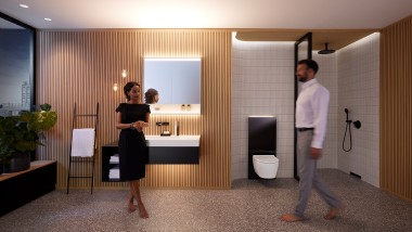 Muškarac i žena u savršeno osvetljenom kupatilu sa Geberit ONE kupatilskim nameštajem i keramičkim aparatima (© Geberit)