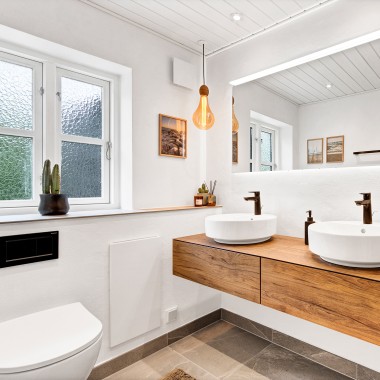Svetlo, renovirano kupatilo sa dva umivaonika, velikim ogledalom i drvenim nameštajem (© @triner2 and @strandparken3)